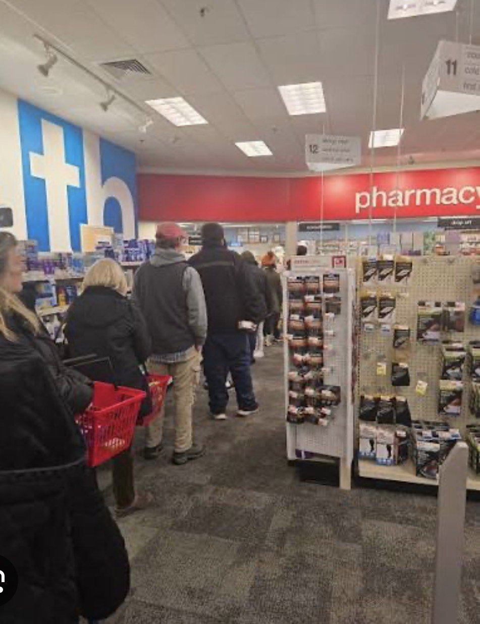 Long line of customers waiting at a chain pharmacy